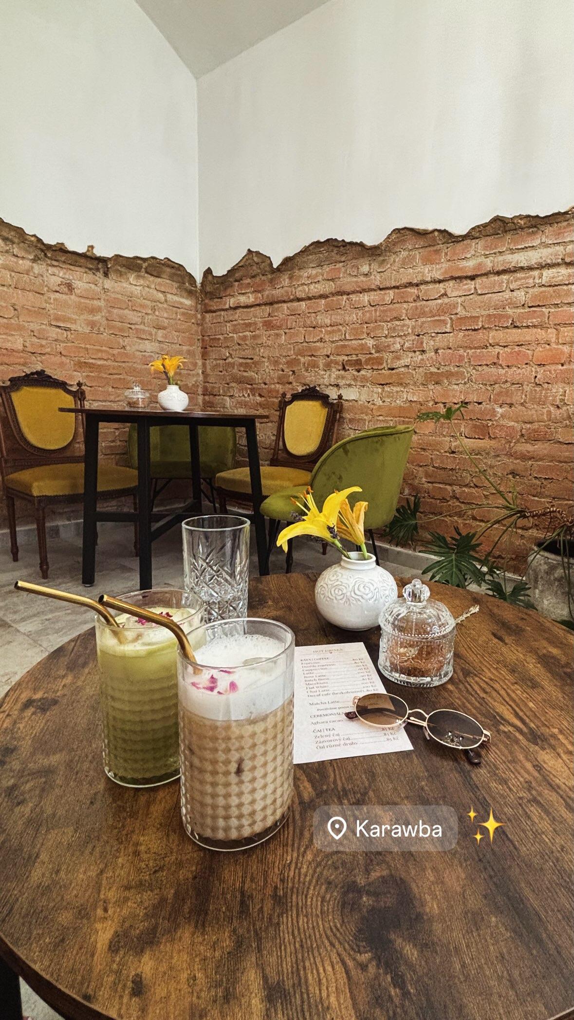 Instagram story from Karawba: two iced drinks on a wooden table in a cafe with an exposed brick wall and yellow velvet chairs